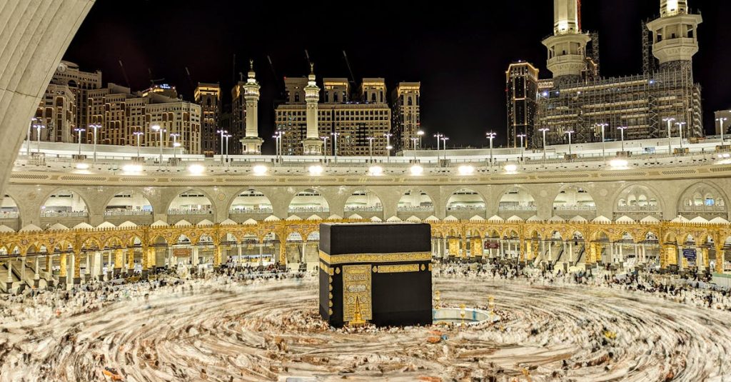 Vibrant night view of the Kaaba in Mecca, capturing Islamic architecture and worshippers.